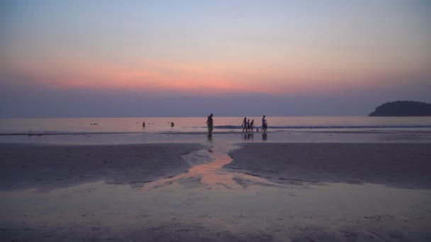 turisteja kävelemässä rannalla hämärässä klo Kata ranta Phuket Thaimaa
 - Materiaali, video