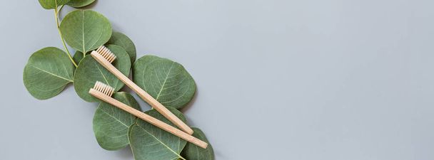 eco natural bamboo toothbrushes flat lay on gray background. sustainable lifestyle concept. zero waste, plastic free items. stop plastic pollution. Top view, overhead, template, Mockup. - Foto, imagen
