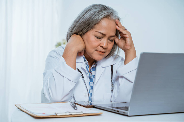 Senior woman doctor using laptop - Foto, afbeelding