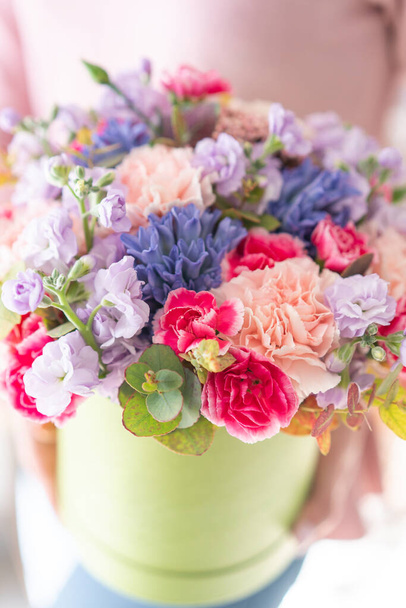 European floral shop. Floral bunch in round box. Bouquet of beautiful Mixed flowers in woman hand. Excellent garden flowers in the arrangement , the work of a professional florist. - Foto, imagen