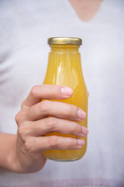 Juice in bottle in woman hand - Fotoğraf, Görsel