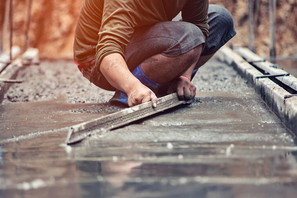 Рабочие регулируют гладкую поверхность бетона
. - Фото, изображение