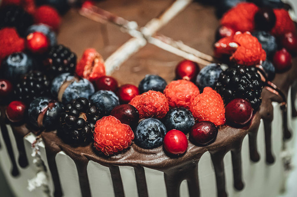 weißer Kuchen mit Schokoglasur und Beeren, Geburtstagstorte in Großaufnahme - Foto, Bild