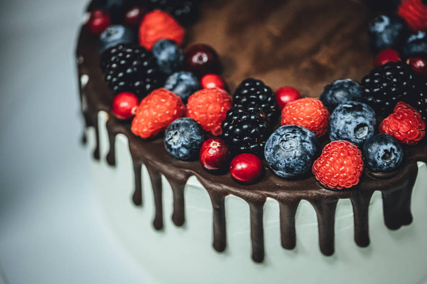 White cake with chocolate glaze and berrys, birthday cake in close up - Zdjęcie, obraz