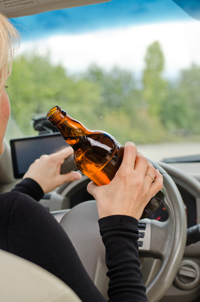 Femme conduisant tenant une bouteille d'alcool
 - Photo, image