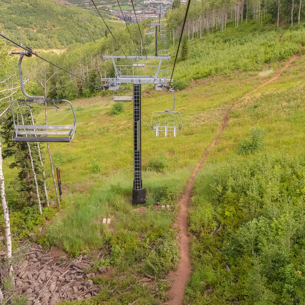 Square frame Off season in Park City with hiking trail amid grasses and chairlifts overhead - Photo, Image