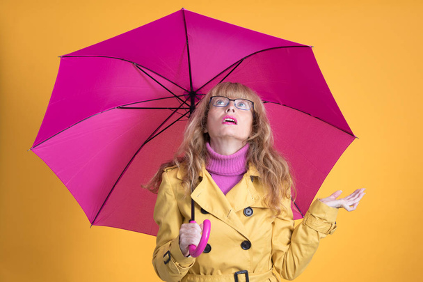 mujer con paraguas abierto sobre fondo amarillo
 - Foto, imagen