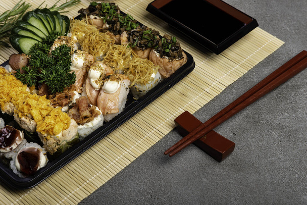 Assiette complète de sushi pour livraison sur fond gris
. - Photo, image