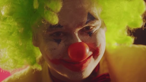 Klaun z rozpadającą się farbą na twarzy przerażający uśmiech - Materiał filmowy, wideo