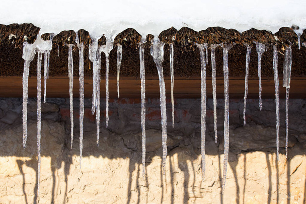 fila de icicles no telhado de palha
 - Foto, Imagem
