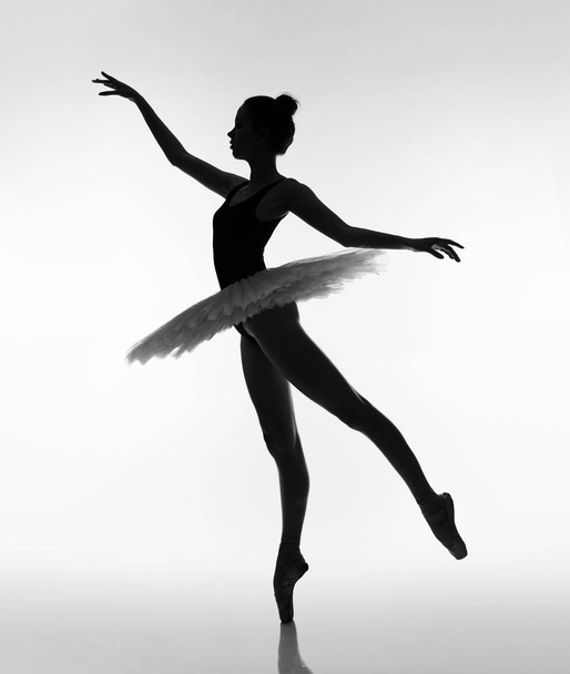 Lány táncol balett tütüben és pointe cipőben. Fekete-fehér fénykép. - Fotó, kép