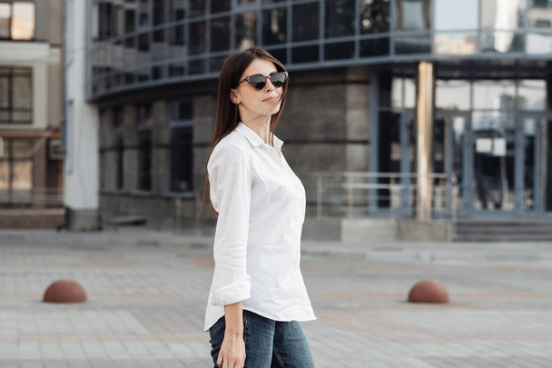 Portret jednej modnej dziewczyny ubranej w dżinsy i białą koszulę, Business Lady, Kobieca koncepcja mocy - Zdjęcie, obraz