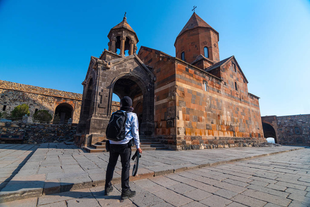 Mochilero asiático viajero mano mano cámara de pie en el Khor Virap, monasterio armenio
 - Foto, Imagen