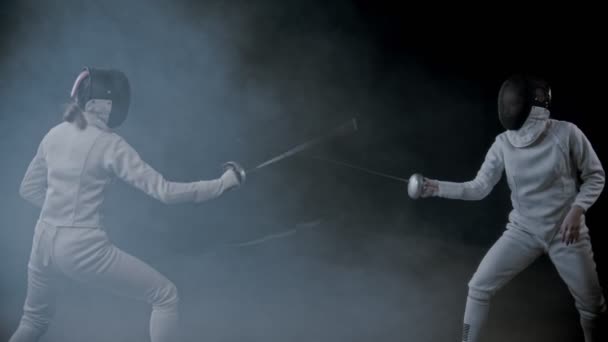 Обучение фехтованию - две молодые женщины, устроившие поединок в дымящейся студии - тыкают друг в друга
 - Кадры, видео