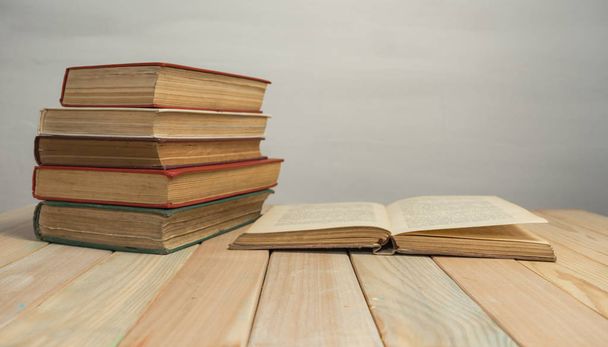 Old Books on a wooden table and white wall background.  - Фото, зображення