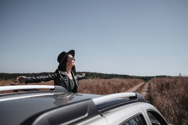 Retrato da menina viajante feliz que gosta de uma viagem de carro na estrada de campo
 - Foto, Imagem