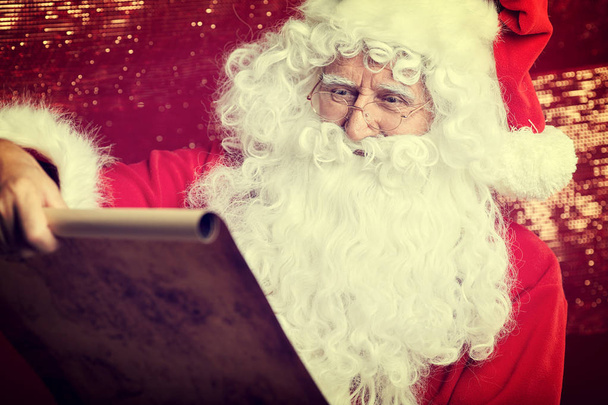Checking his special list. Traditional Santa Claus sitting - 写真・画像