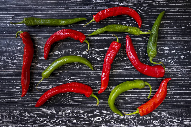 Red and green chili pepper on a black wooden vintage background. - Photo, Image