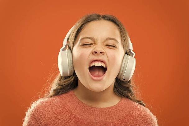 For better vocal performances. Adorable small child doing vocal on song. Little girl listening to music and singing vocal melody. Talented singer or vocalist training her vocal in wireless headphones - Photo, Image
