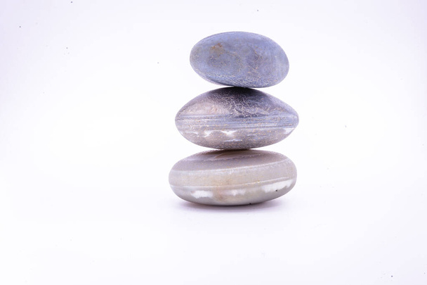 Hromada kamenů izolovaných na bílém pozadí, Kameny pro masáž a zenový životní styl. Mystické kameny v rovnováze. - Fotografie, Obrázek