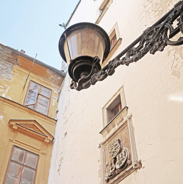 Вид на старый фонарь на улице Братиславы, Словакия. Старые ветхие здания на заднем плане. Винтажный фильтр
 - Фото, изображение