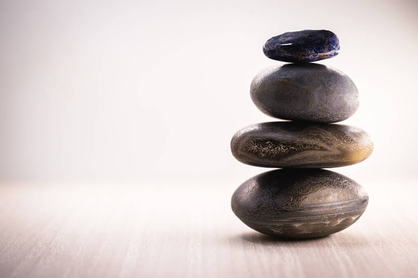 Pilha de pedras spa sobre a mesa contra um fundo branco, espaço para texto. Pedras Zen para meditação e cura mística
. - Foto, Imagem
