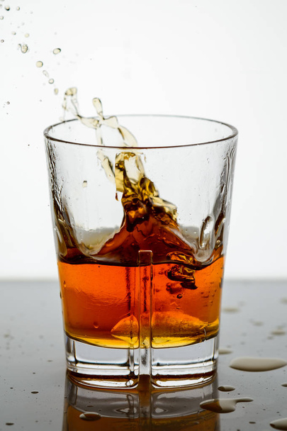 splashing whiskey in a glass on the background15 - Foto, Imagem