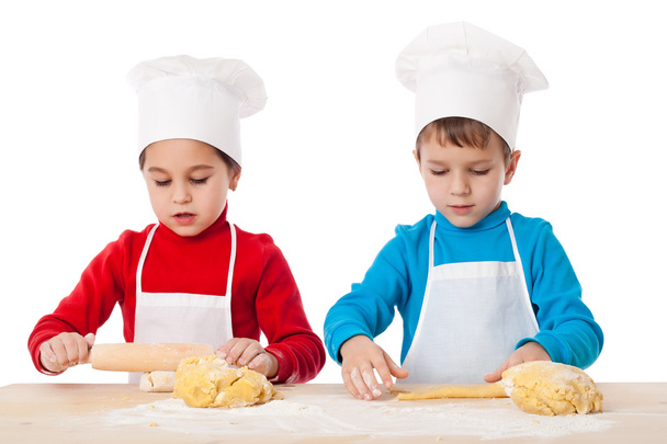 Two kids kneading the dough together - Fotó, kép
