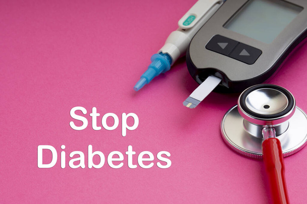 Spuit, glucosemeter of glucosemeter en stethoscoop met woorden Stop diabetes op roze achtergrond. Diabetes-concept.  - Foto, afbeelding
