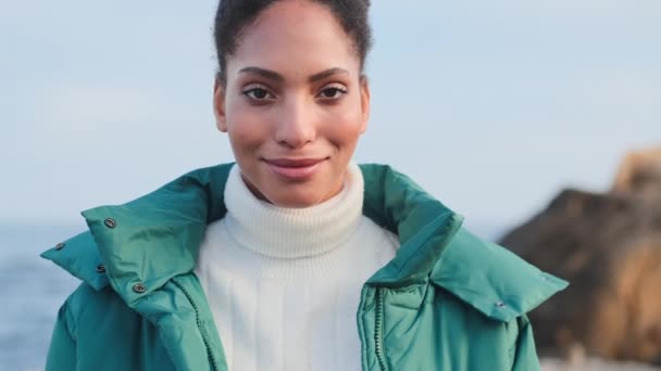 Attrayant casual afro-américaine fille heureuse de regarder à la caméra sur le bord de la mer
 - Séquence, vidéo