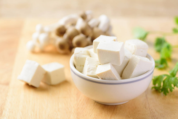 Krájené tofu v misce a houby shimeji na dřevěném pozadí pro vegetariánské vaření - Fotografie, Obrázek
