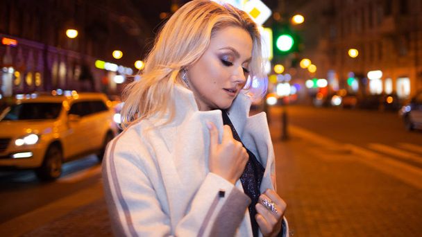 Stylish and elegant young woman in a beige coat on the city . - Foto, Imagen