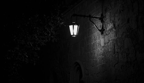 Allée noire et blanche effrayante avec un lampadaire allumé
 - Photo, image