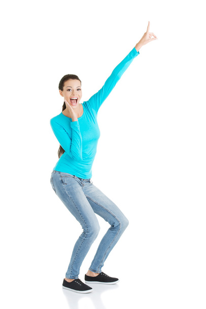 Excited young woman pointing on copy space - Foto, imagen
