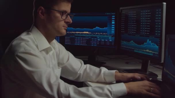 Trader working in office at night using workstation and analysis technology. Stock markets, crypto currency, global business, financial trading and banking concept. - Footage, Video