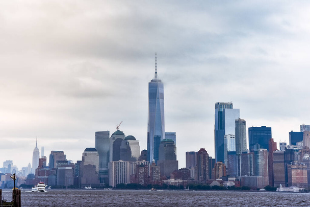 Stadsgezicht van het financiële district Manhattan van Liberty Island, in een mistige dag. - Foto, afbeelding