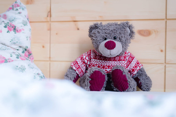 Cute teddy bear toy is sitting in the bed, wakeup at morning - Foto, imagen