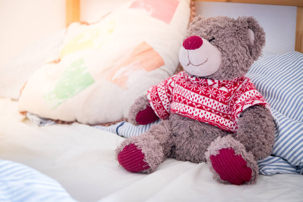 Cute teddy bear toy is sitting in the bed, wakeup at morning - Foto, immagini