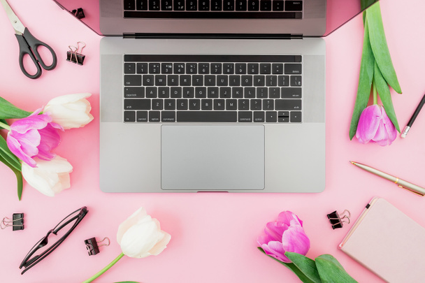 Laptop, diario, flores, gafas, bolígrafo y tijeras en rosa. Plano
  - Foto, imagen