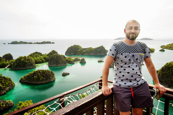 Caucasian man standing at the viewpoint of Piaynemo island, Raja - Foto, imagen
