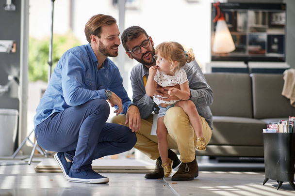 gay parents with child in store for household - Foto, imagen
