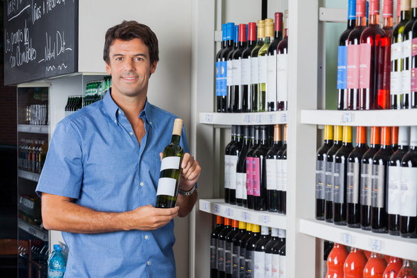 Man Holding Bottle Of Alcohol At Supermarket - Valokuva, kuva