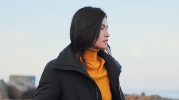 Середній постріл привабливої задумливої азіатської дівчини в піджак задумливо ходячи один на морському узбережжі - Кадри, відео