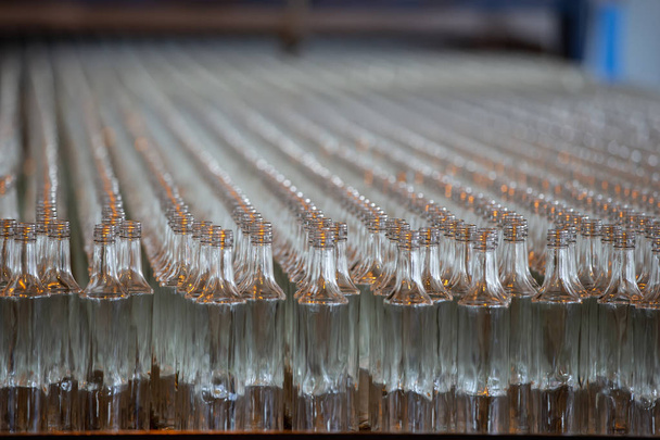 Скляні вироби. Скляна промисловість. Багато скляних пляшок на заводському конвеєрі
. - Фото, зображення