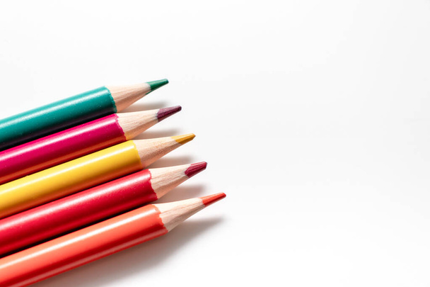 A set, assortment of colorful wooden pencils of different colors laying in row on white background with copy space - Foto, imagen