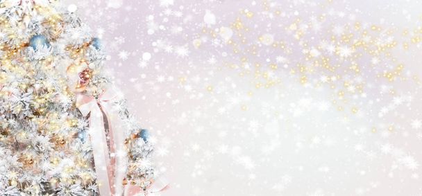 Weihnachtsbanner Hintergrund mit Weihnachtsbaum. Neujahrskarte. Teil eines geschmückten Weihnachtsbaums auf rosa Hintergrund mit Bokeh - Foto, Bild