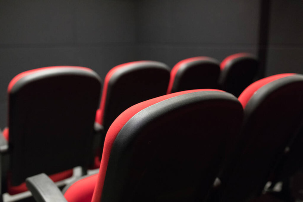 Piros mozi székek vagy fotelek a színházban. Piros székek konferencia- vagy szemináriumi teremben. Üres kis mozi vagy mozi színházi előadóterem piros mozival vagy mozi ülések vagy székek. Kis mozi vagy mozi ülőbútor vagy szék belseje. - Fotó, kép