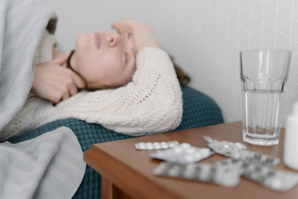 Una donna malata si aggrappa alla testa, ha mal di testa. Malattia influenzale. Infezione e temperatura
 - Foto, immagini