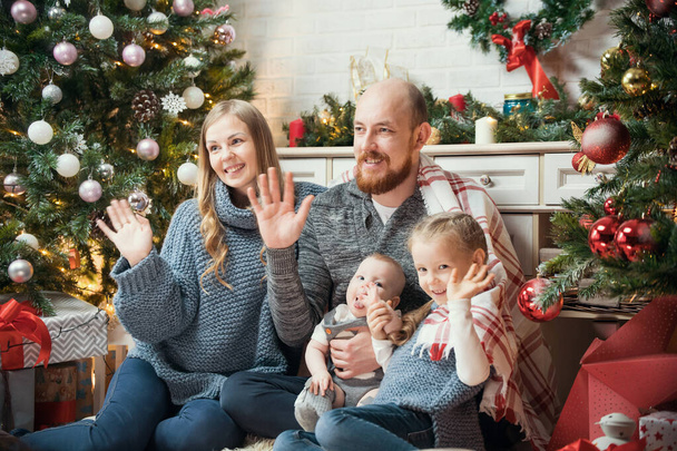 Christmas concept - happy smiling family looking at somebody and waving their hands - Foto, Imagem