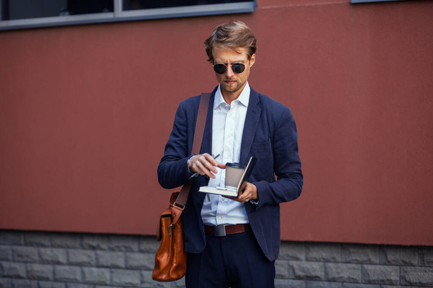 Stylish Businessman With A Notepad And Coffee Is About To Write Something On Paper - Foto, Imagem